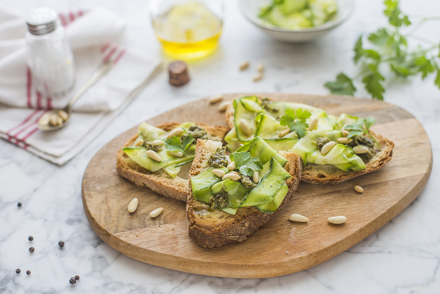 Bruschette con zucchine marinate, pesto e pinoli